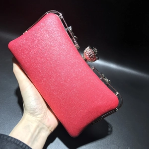 Detail of dark pink glitter evening clutch with silver frame and rose diamond clasp