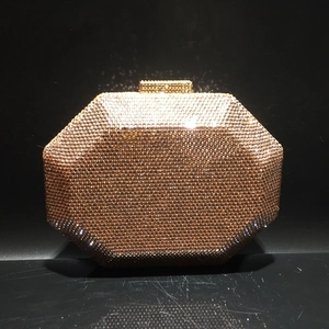 Detail of the champagne gold octagonal clutch featuring dense crystal embellishments