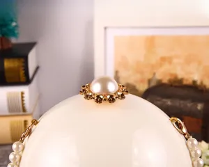 Détail de la pochette de soirée en perles avec grande perle et accents dorés