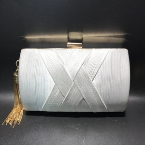 Detail of silver silk clutch bag with gold tassel chains and textured pleats