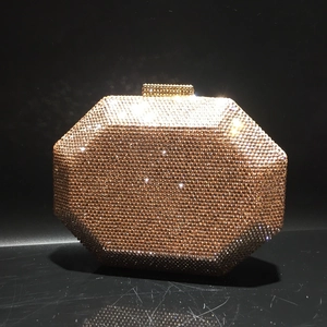 Close-up of champagne octagon clutch bag with sparkling crystals and metal clasp