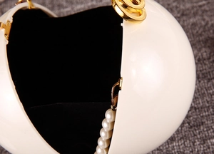 Vue détaillée du sac de soirée perle sphérique avec fermoir doré et doublure intérieure noire