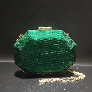 Close-up of emerald green crystal evening bag with gold metal frame and clasp