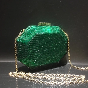 Close-up of emerald green rhinestone octagonal evening bag with golden chain strap