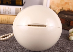 Détail du sac de soirée sphérique avec charnière dorée et poignée en perles élégantes