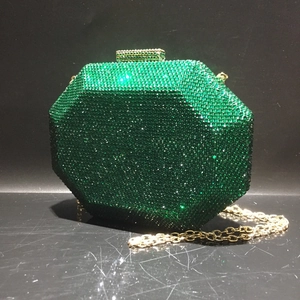 Detail of emerald green crystal hexagon evening bag with golden clasp and chain strap