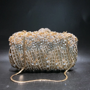 Macro detail of luxury gold floral evening bag featuring intricate crystals and rose texture