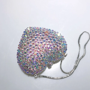 Détail d'une pochette de soirée en forme de cœur avec strass AB et chaîne argentée