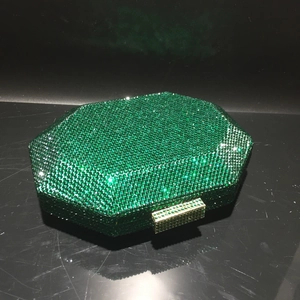 Detailed macro view of the octagonal emerald green rhinestone clutch bag and gold clasp