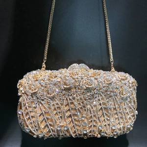 Detailed shot of a luxury gold evening clutch bag with sparkling floral crystal rhinestones