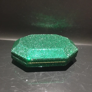 Macro shot of green crystal evening clutch bag with gold metallic trim and secure clasp