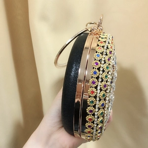 Macro detail of round evening bag with colorful crystals and circular gold handle