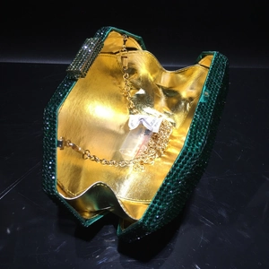 Detail of dark green rhinestone evening bag showing gold interior and chain strap