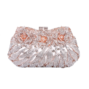 Detail of rose gold evening clutch featuring 3D metal flowers and sparkling crystals