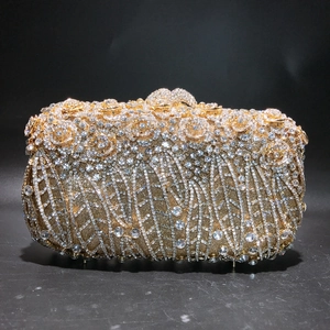 Detailed close-up of sparkling crystals and golden metal roses on a luxury evening clutch bag