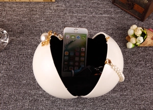 Détail du grand sac de soirée sphérique blanc montrant l'intérieur et la poignée en perles
