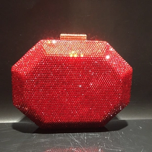 Macro detail of red octagonal evening clutch with shimmering crystals and gold clasp