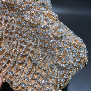 Macro detail of luxury evening clutch with hollow rose pattern and crystal inlay