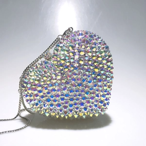 Détail du sac de soirée en forme de cœur avec strass irisés et fine bandoulière en chaîne