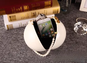 Détail du sac de soirée sphérique blanc montrant l'espace intérieur pour smartphone