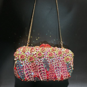 Close-up of floral crystal evening clutch with red lips clasp and gold chain strap