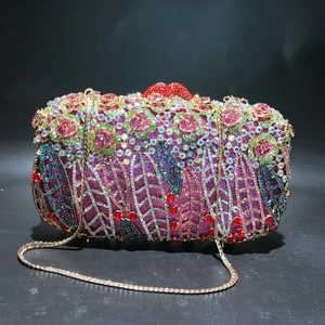 Detailed close-up of crystal-encrusted evening bag with pink rose and red lip clasp