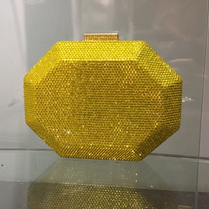 Detailed view of an octagonal yellow crystal evening clutch bag with golden clasp