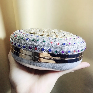 Close-up of a circular evening clutch with colorful crystals and a gold metal frame
