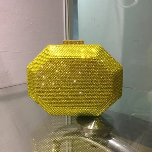 Close-up of bright yellow octagonal evening clutch bag with sparkling crystal rhinestones