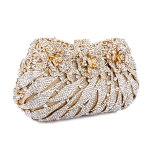 Close-up of golden metal evening clutch featuring hollow rose flower and sparkling rhinestones