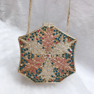 Close-up of hexagonal evening bag with colorful snowflake crystals and gold chain strap