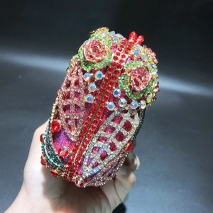 Macro detail of multicolored crystals and gold floral metalwork on luxury evening clutch