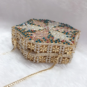 Close-up of snowflake crystal evening bag with colorful rhinestones and gold metal chain