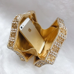 Detail of hollow snowflake crystal evening clutch with gold chain and interior space