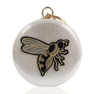 Circular silver glitter evening bag with embroidered bee motif and gold ring handle