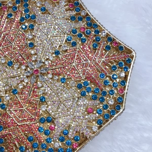 Close-up of geometric evening bag featuring colorful snowflake crystals and gold frame
