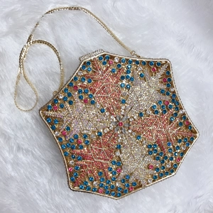 Detail of hexagonal evening clutch featuring blue and pink crystals on faux fur
