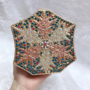 Close-up of hexagonal snowflake evening bag with blue and pink rhinestones and gold frame
