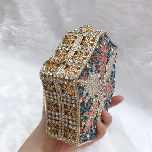 Detailed view of an octagonal metal clutch featuring snowflake cut-outs and colorful crystals