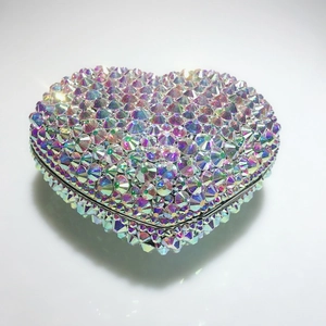 Détail macro d'un sac de soirée en forme de cœur avec cristaux irisés et fermoir métallique