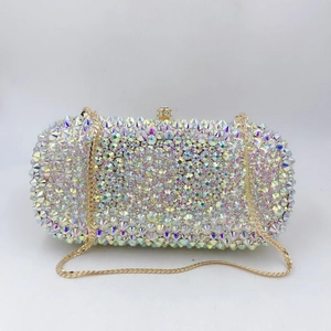 Close-up of sparkling AB crystal rhinestones and gold chain on luxury evening clutch