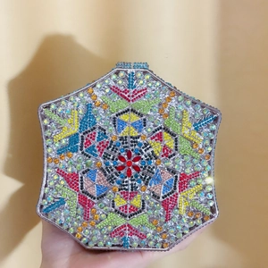 Close-up of a hexagonal evening clutch bag with colorful rhinestones in a geometric pattern