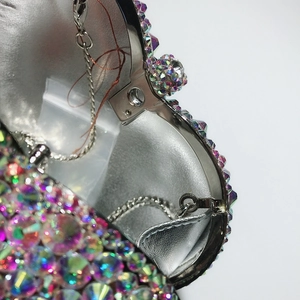 Détail de la pochette de soirée montrant le fermoir en métal et les strass brillants