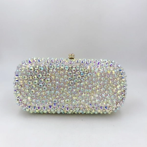 Close-up of AB white crystals and gold spherical metal clasp on evening clutch bag