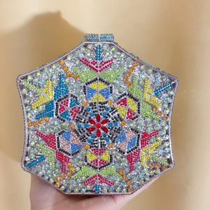 Detailed close-up of a hexagonal evening clutch bag featuring colorful inlaid crystals