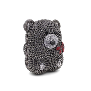 Détail d'une pochette ours en peluche faite main avec strass gris fumé et nœud rouge