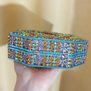 Detailed macro view of colorful rhinestones on a hollow metal evening clutch bag