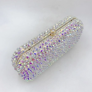 Detail of luxurious evening clutch featuring crystal rhinestones and golden metal frame