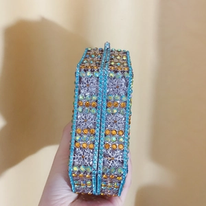 Detail of evening clutch bag featuring snowflake crystal patterns and hollow metal craft