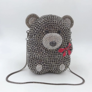 Détail de la pochette ours en peluche avec cristaux gris et nœud en strass rouge brillant